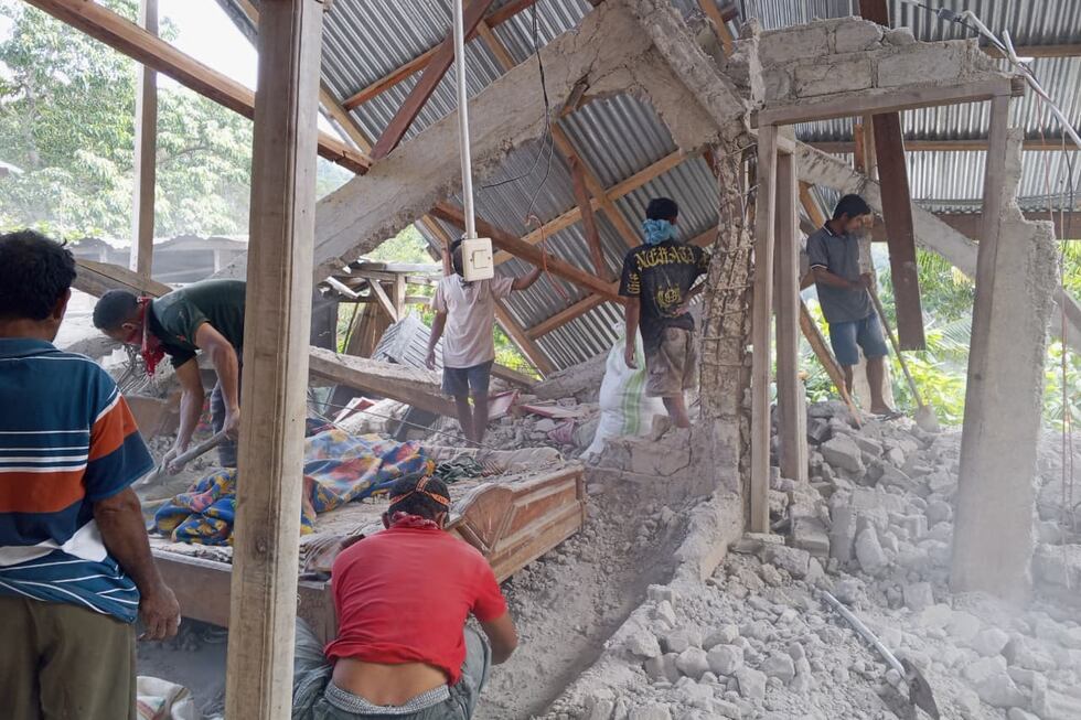 Varias personas retiran escombros de una casa destruida por un terremoto, el sábado 15 de...