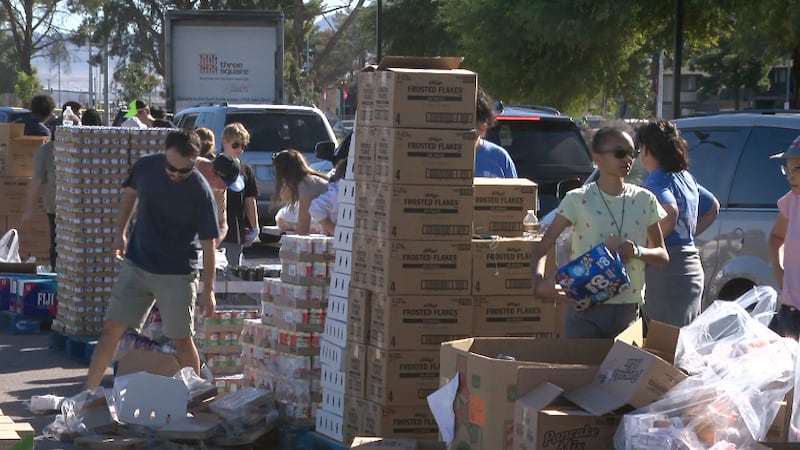 Voluntarios organizan cajas de comida en un centro de distribución del banco de alimentos...