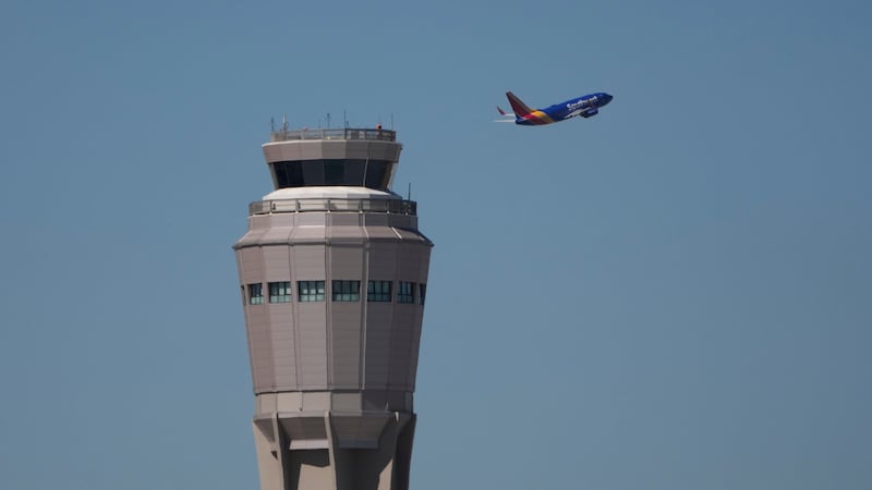 A plane takes off near the air traffic control tower at Harry Reid International Airport,...