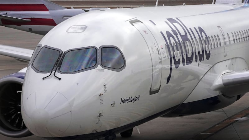 FILE - A Jet Blue Airlines jet pushes back from a gate at the Pittsburgh International Airport...