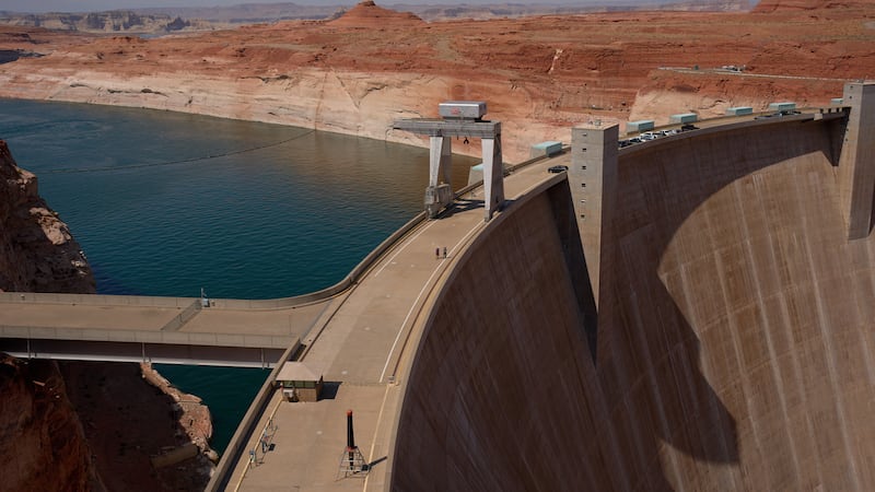 People walk across the Glen Canyon Dam near Lake Powell at the Glen Canyon National Recreation...