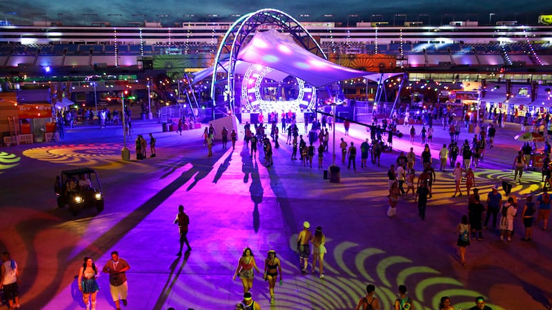 FILE - In this June 20, 2014 file photo people walk around a stage during the Electric Daisy...