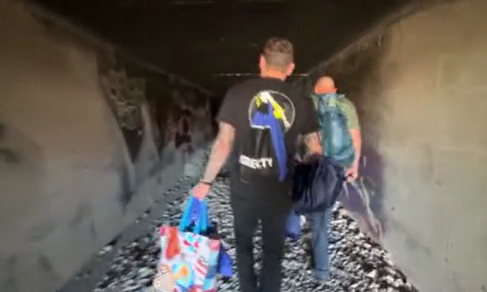 Activistas de la Fundación Shine A Light ingresan a un túnel de canal de drenaje pluvial...