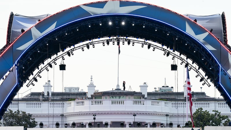 ARCHIVO - Un agente de seguridad en la Casa Blanca utiliza prismáticos durante el UFC Fan Fest...