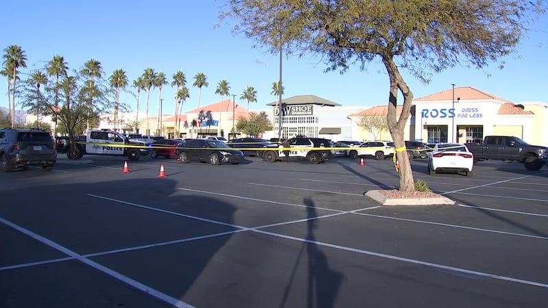 Vehículos policiales bloquean el estacionamiento de un centro comercial en North Las Vegas,...