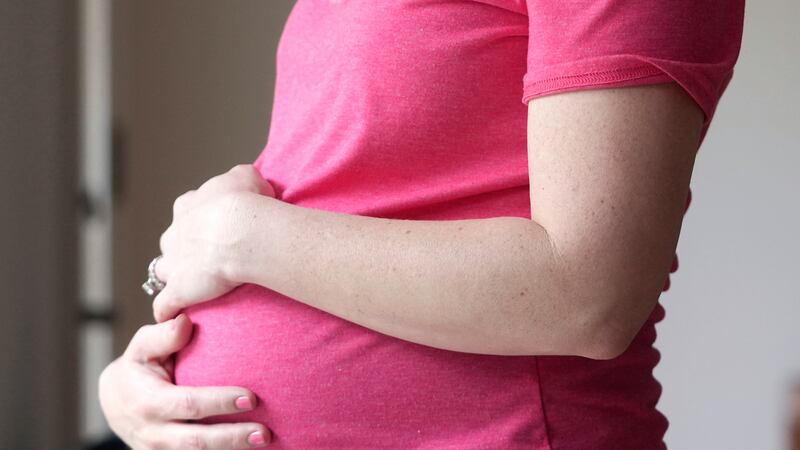 FILE - A pregnant woman stands for a portrait in Dallas, Thursday, May 18, 2023. (AP Photo/LM...
