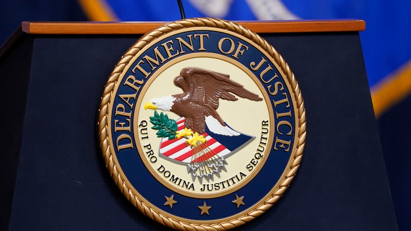 FILE - The seal for the U.S. Department of Justice is displayed on a podium in Washington,...