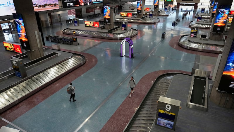 People walk through Harry Reid International Airport, Friday, Aug. 29, 2025, in Las Vegas. (AP...