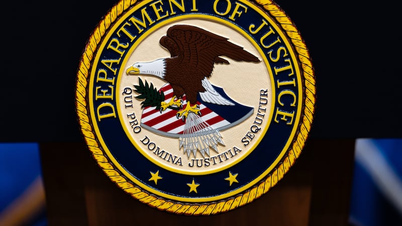 The U.S. Department of Justice logo is seen on a podium before a news conference, Monday, May...