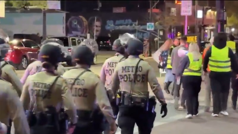 Ambos lados de la calle estaban llenos de personas sosteniendo carteles y cantando, con la...
