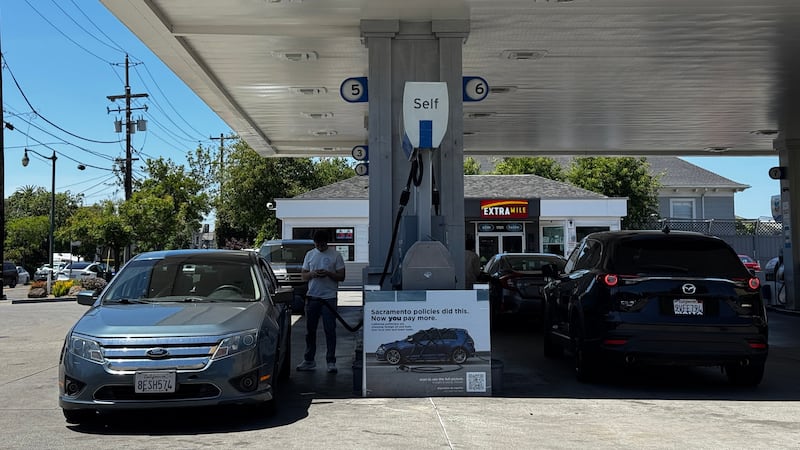 Un letrero en el que se culpa a las políticas del estado por el elevado costo de la gasolina,...